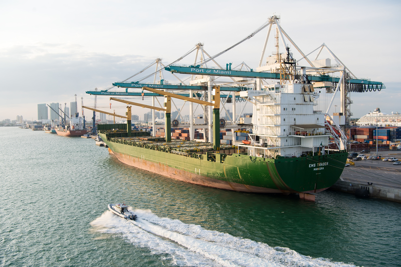 Cargo ship with cranes in sea port.